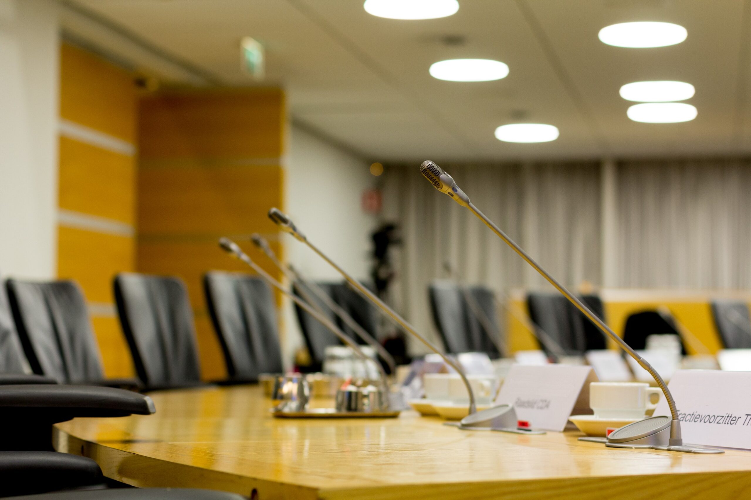 Een close-up van spreekondersteuningsmicrofoons in de raadzaal van het stadhuis van Purmerend
